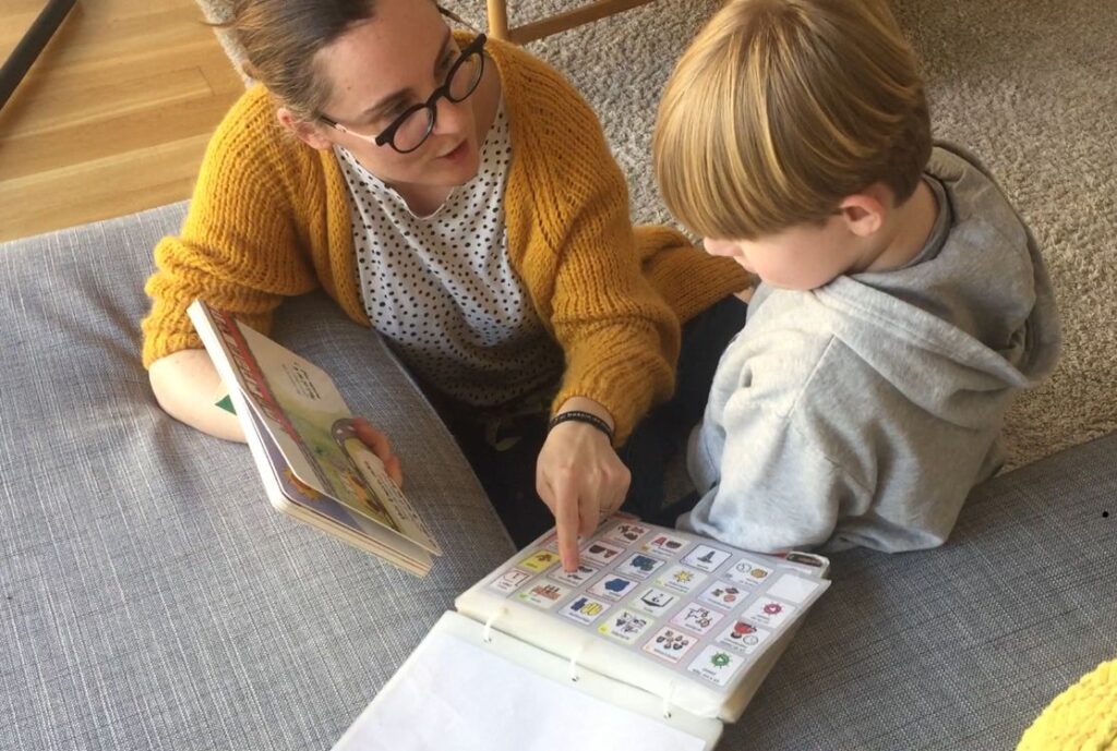 une femme qui communique via un podd avec un enfant